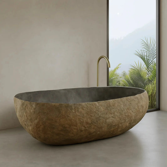 Baignoire à poser en pierre naturelle, sculptée dans un galet. Parois fines, intérieur gris brillant, extérieur brut. Pour une salle de bain design et minérale.