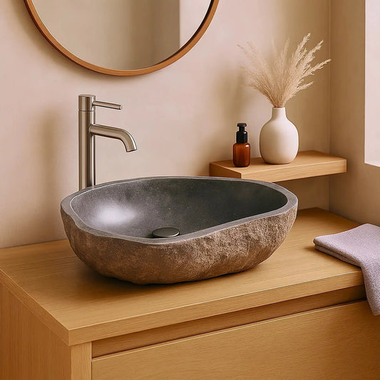 Vasque sculptée dans un galet naturel avec intérieur marbre gris brillant. Pièce unique, finitions soignées, dimensions 52-60 cm, évacuation incluse.